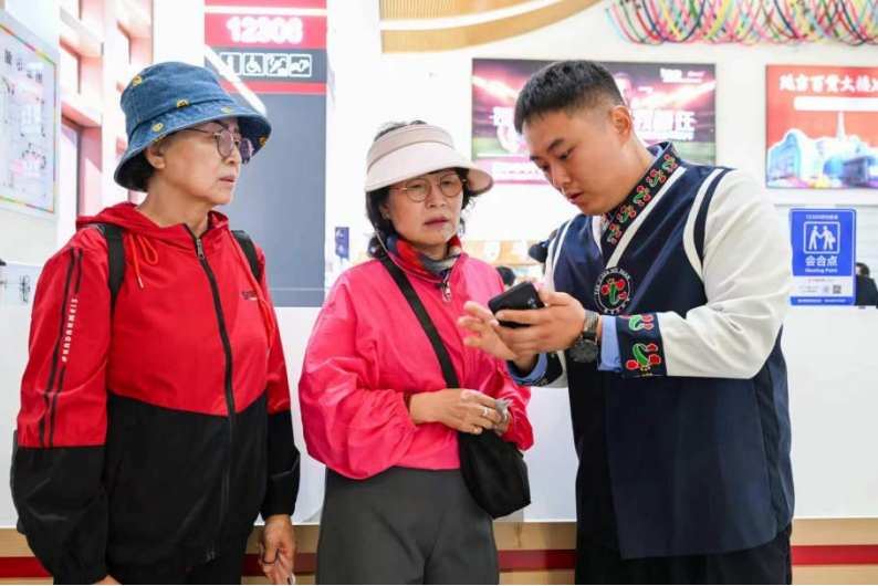 客运值班员石清赫正在为旅客提供服务。陈明 摄